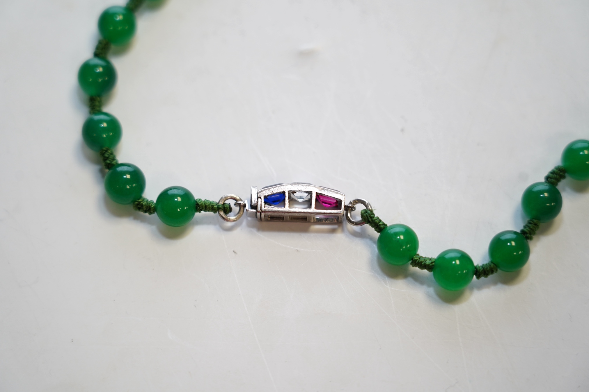 A single strand jadeite bead necklace, with simulated gemstone set clasp, 56cm. Condition - fair